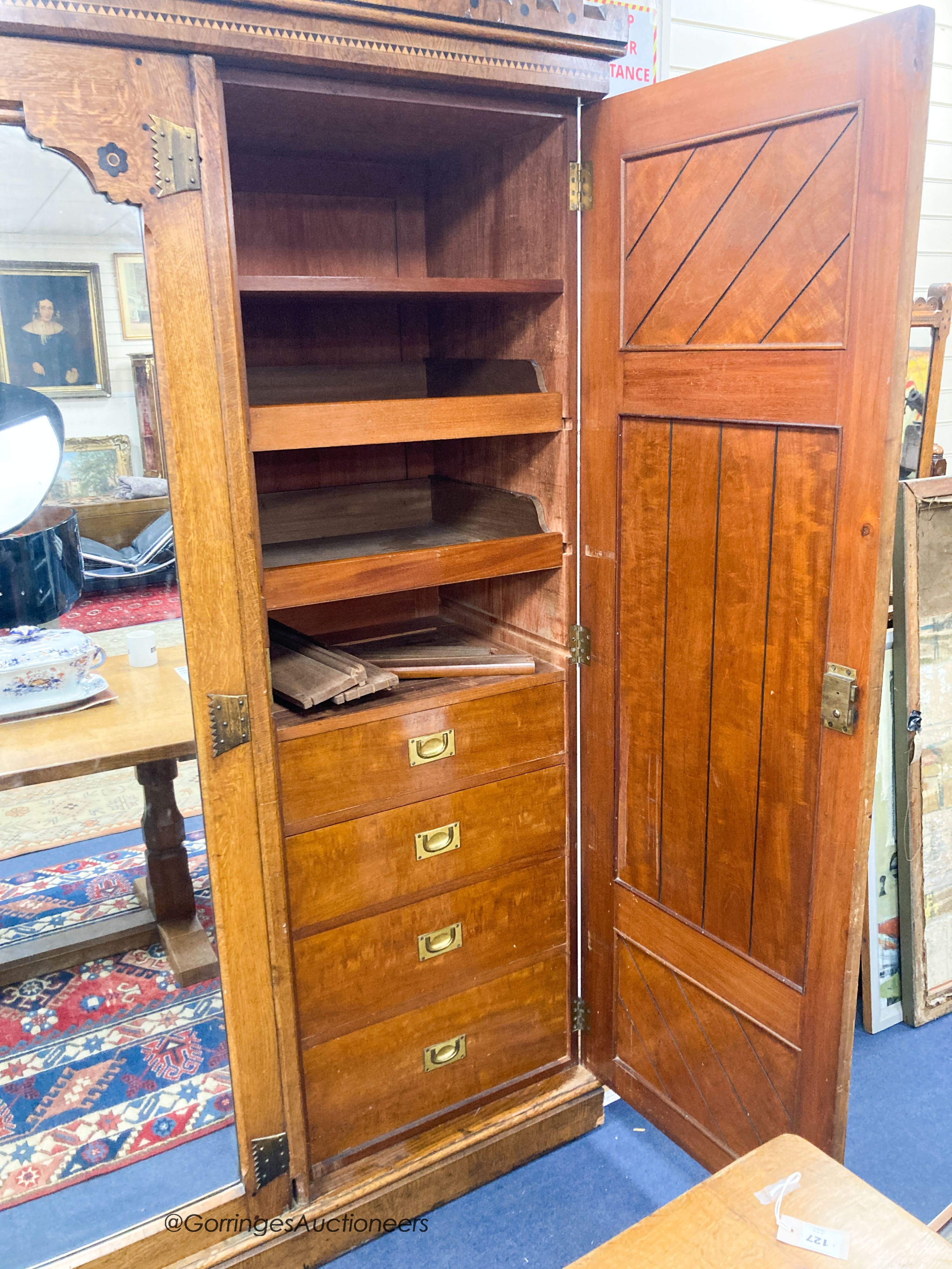 A late Victorian inlaid oak and pollard oak Aesthetic movement three door mirrored wardrobe by Garnett & Son, Warrington, length 216cm, depth 64cm, height 213cm